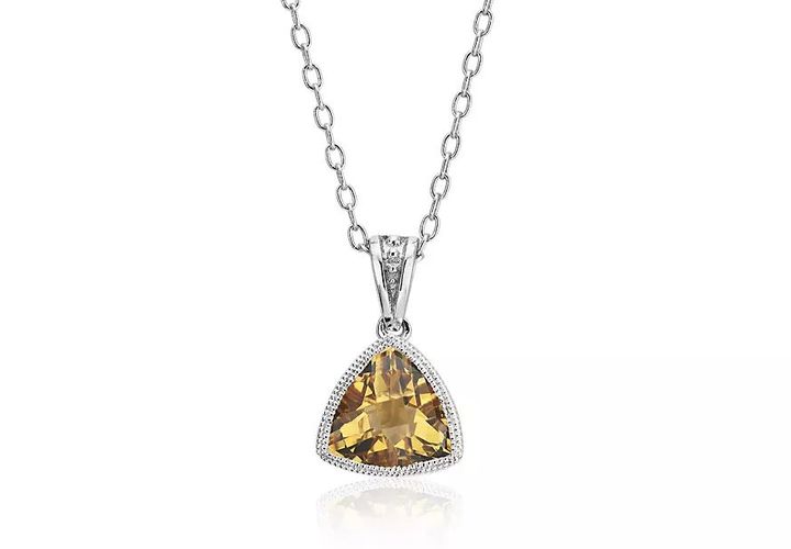 A trillion-cut citrine gemstone in a white gold bezel-set pendant framed white vintage-inspired milgrain